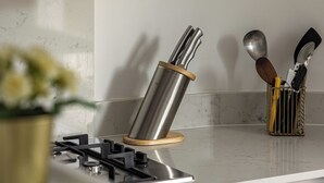 Una cocina con estufa a gas, utensilios de acero inoxidable y diseño moderno.
