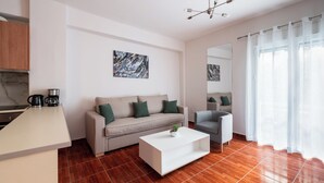 A modern living room with a sofa, a coffee table, and a dining area.