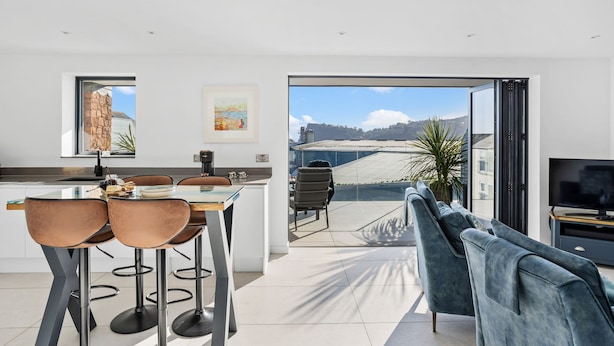 A modern kitchen with a dining area, a large window, and a view of the outside. - Estuary View -  Secure Parking - Nearby Beach (Teignmouth)
