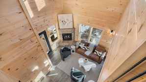 A cozy cabin interior with a stone fireplace, wooden walls, and a comfortable seating area. - VIEWS FROM THE MOUNTAIN TOP is Ready for Company (SEVIERVILLE)