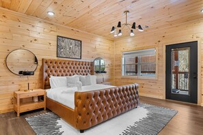 Relax in a classic bedroom with a tufted headboard bed, round mirror, and black floor lamp.