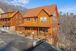 Experience the charm of a log cabin-style hotel with a cozy porch and inviting outdoor seating.