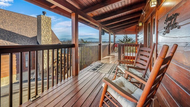 A wooden deck with a stone chimney, wooden railings, and a sign reading "Country Lodge". - A Lake Resort Property with Stunning Views (Sevierville)