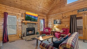 A cozy cabin interior with a stone fireplace, a television mounted above it, and a sign reading "LAKE HOUSE". - A Lake Resort Property with Stunning Views (Sevierville)