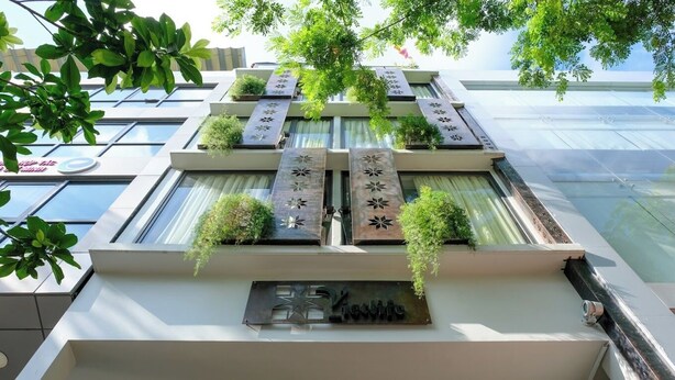 Un hôtel à l’architecture moderne, doté d’une façade élégante, de grandes fenêtres et de jardins verticaux.