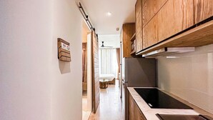 Une cuisine étroite avec des meubles en bois, un évier en acier inoxydable et un plan de travail.