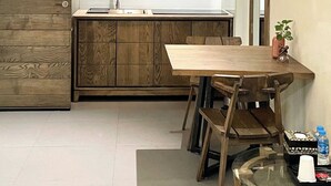 Une cuisine moderne avec des meubles de rangement en bois, une table à manger et des chaises.