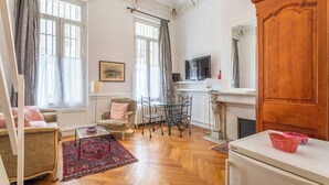 Una sala de estar con chimenea, televisor y comedor con mesa y sillas.