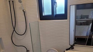 Un baño moderno con inodoro, lavamanos y ducha.
