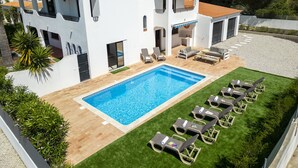 A two-story building with a swimming pool and outdoor seating. - Villa Bellegarde (Albufeira)