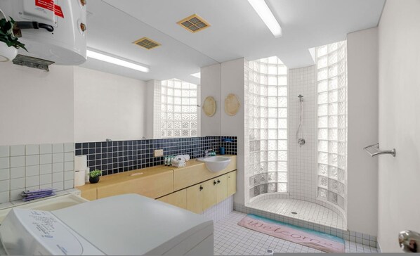 A modern bathroom with a bathtub, a sink, and a shower area.