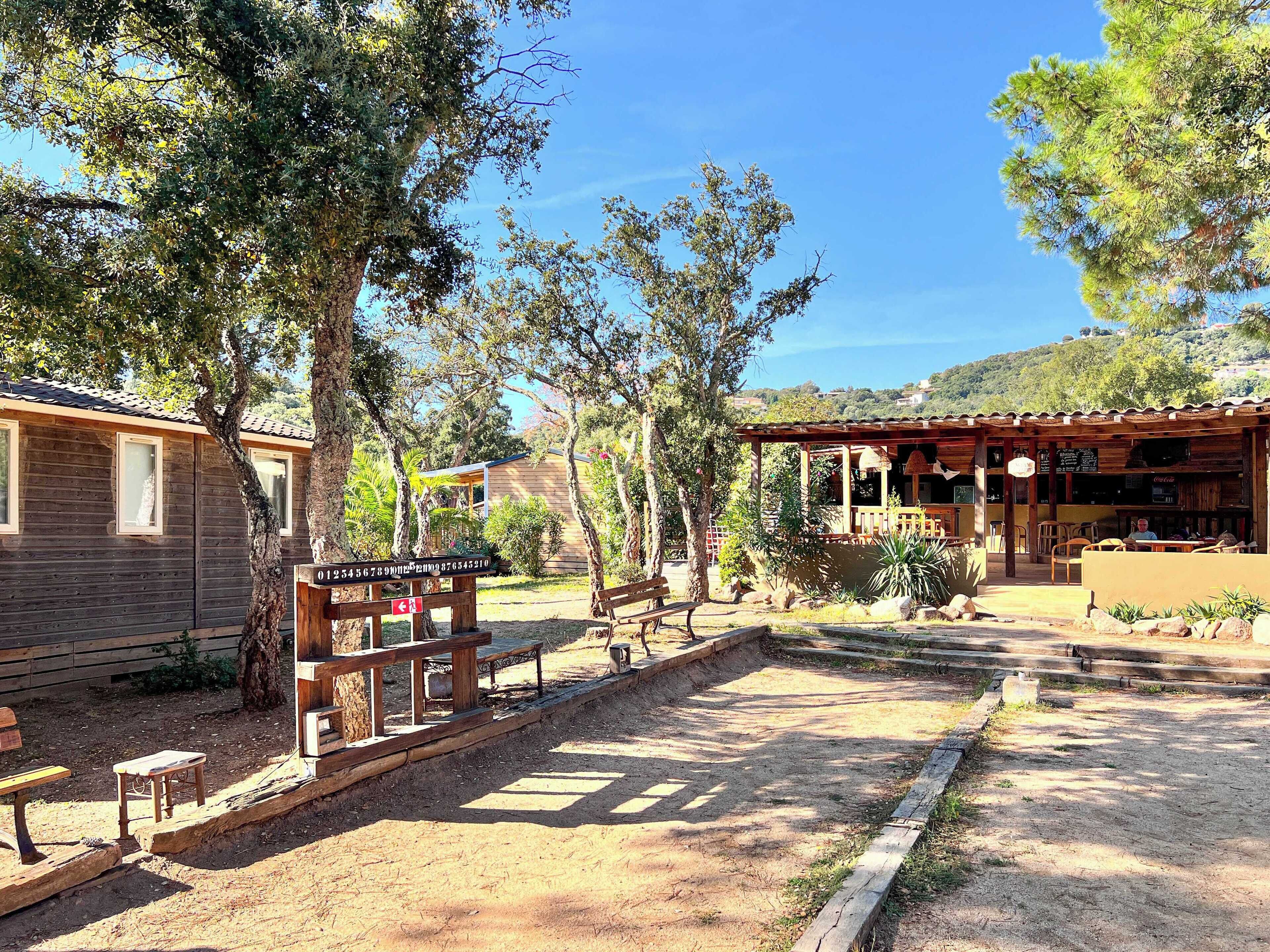 Un bâtiment rustique en bois, doté d’un patio, d’une clôture en bois et d’une enseigne indiquant les coordonnées.