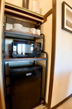 Une petite cuisine équipée d’un four à micro-ondes et d’un mini-réfrigérateur.