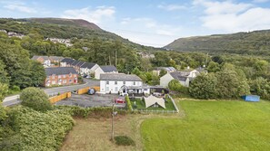 A residential area with houses, a parking lot, and a small building with a white facade. - Unique Exclusive Pub Sleeping up to 26 People (Pontardawe)