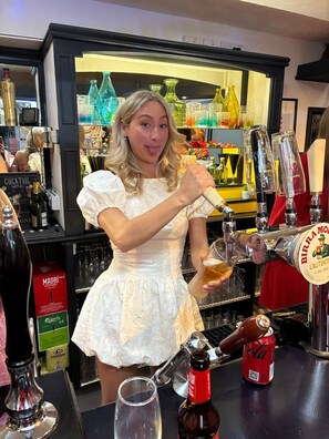 Une personne verse une boisson d’un robinet portant l’inscription « Birra Moretta » dans un verre.