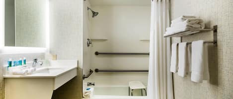 A modern bathroom with a shower, a bathtub, a vanity with a sink, and a mirror.
