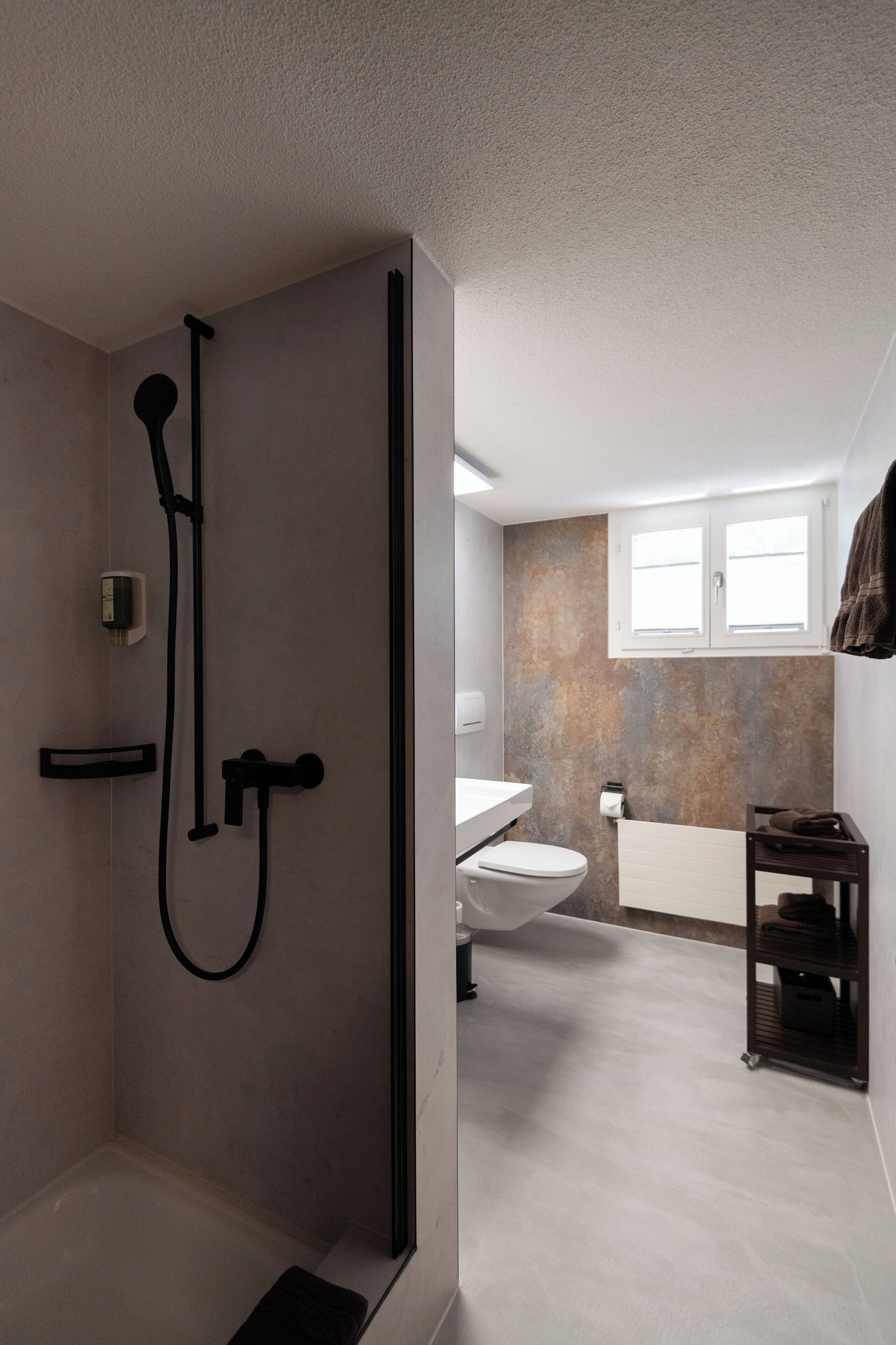 Une salle de bain moderne avec une douche à l’italienne, des toilettes et un lavabo.