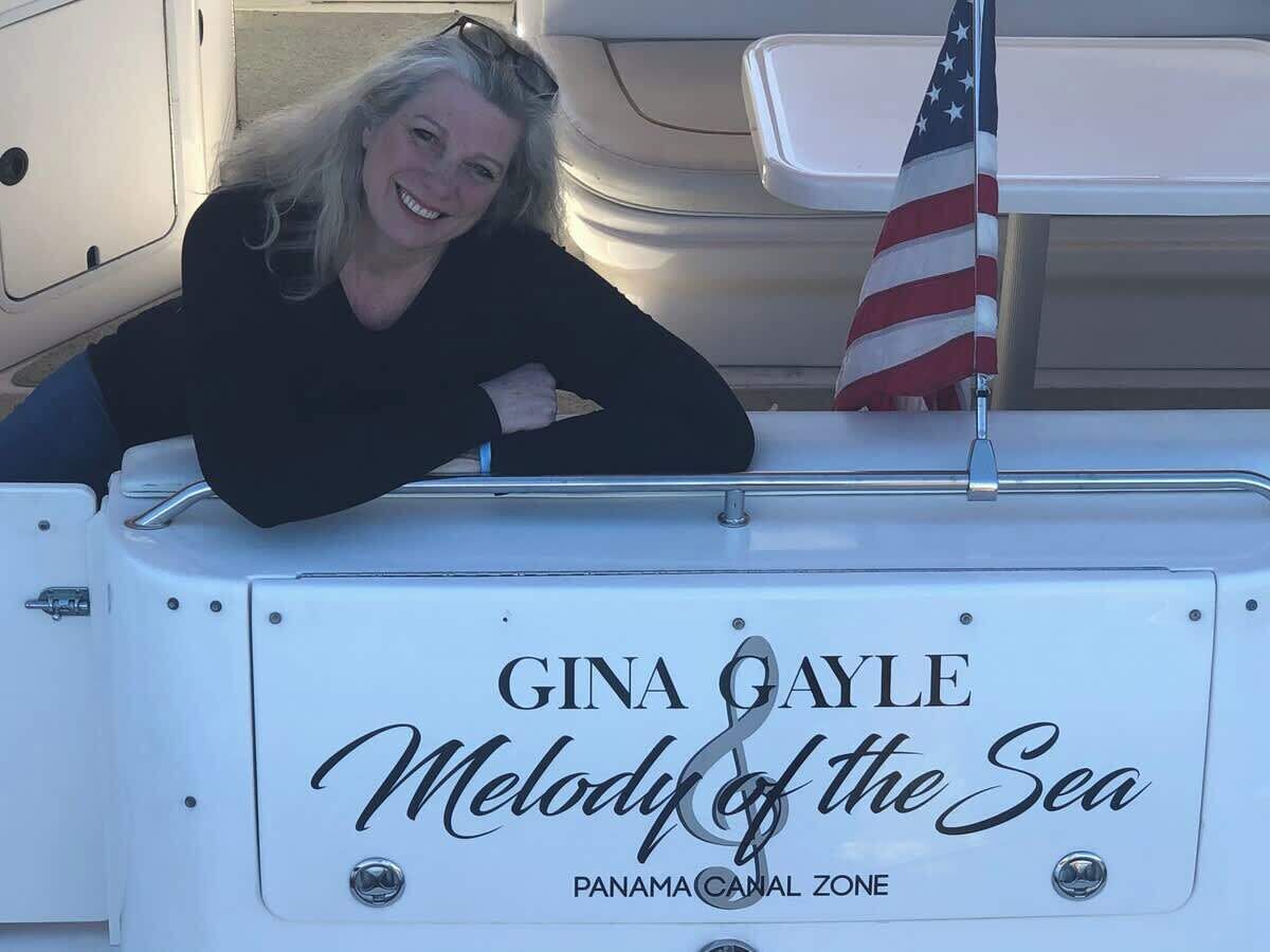 Ein Boot mit einem Schild, auf dem 'Gina Gayle Melody of the Sea Panama Canal Zone' steht.