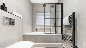 Ein modernes Badezimmer mit Toilette, Badewanne und Dusche.