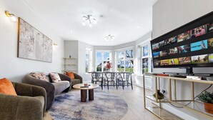 Ein modernes Wohnzimmer mit einer Couch, einem Couchtisch und einem Fernseher.