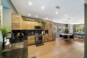 Enjoy cooking in the well-equipped kitchen with a central island, sink, and stainless steel appliances.