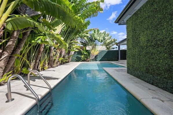 Relax by the serene pool surrounded by lush tropical foliage and banana trees.