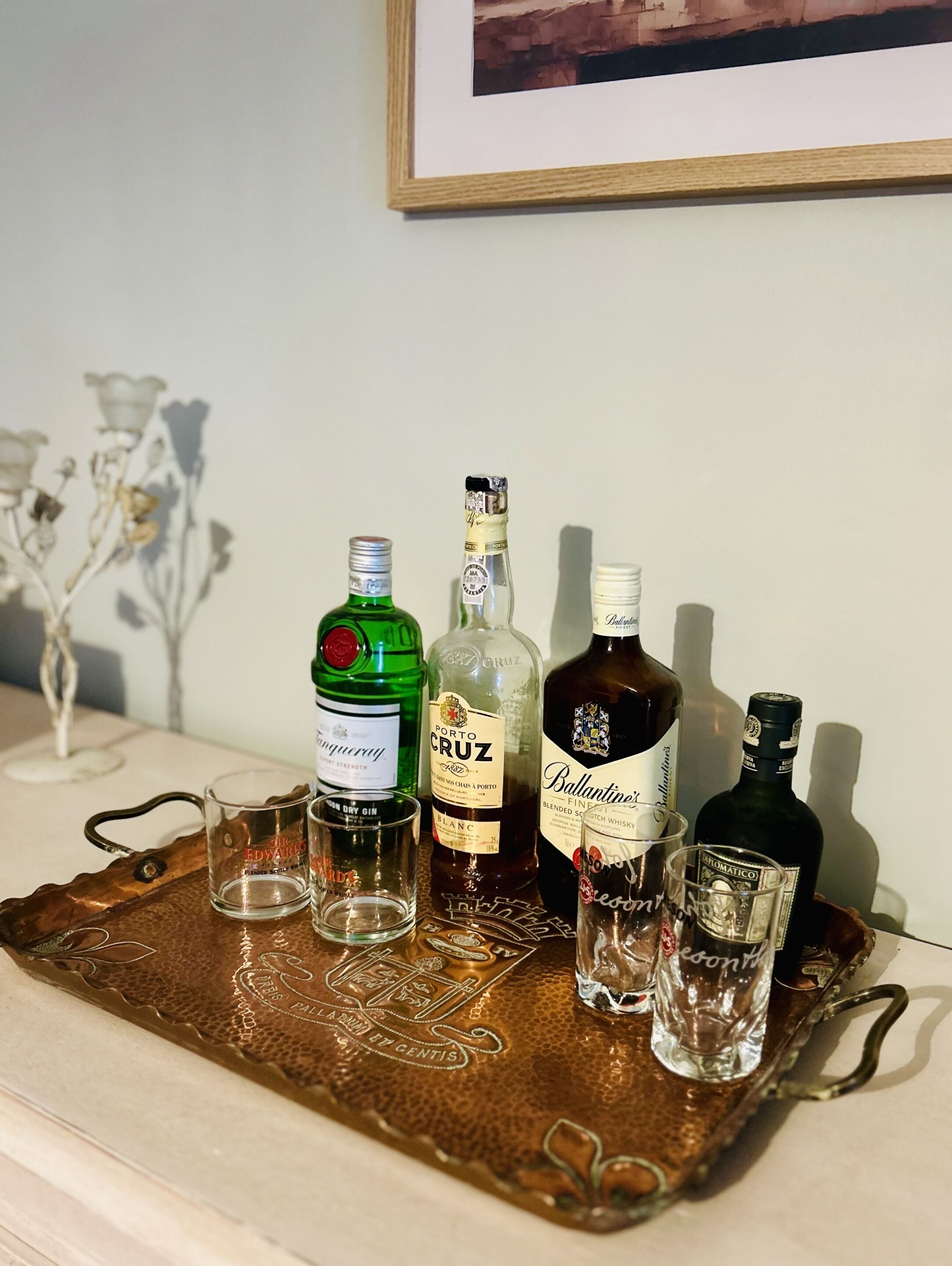 Un plateau contenant diverses bouteilles de spiritueux et des verres, posé sur une table.