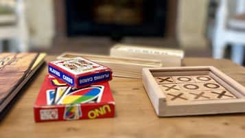 Une table en bois, avec un jeu de cartes et un jeu de Scrabble.