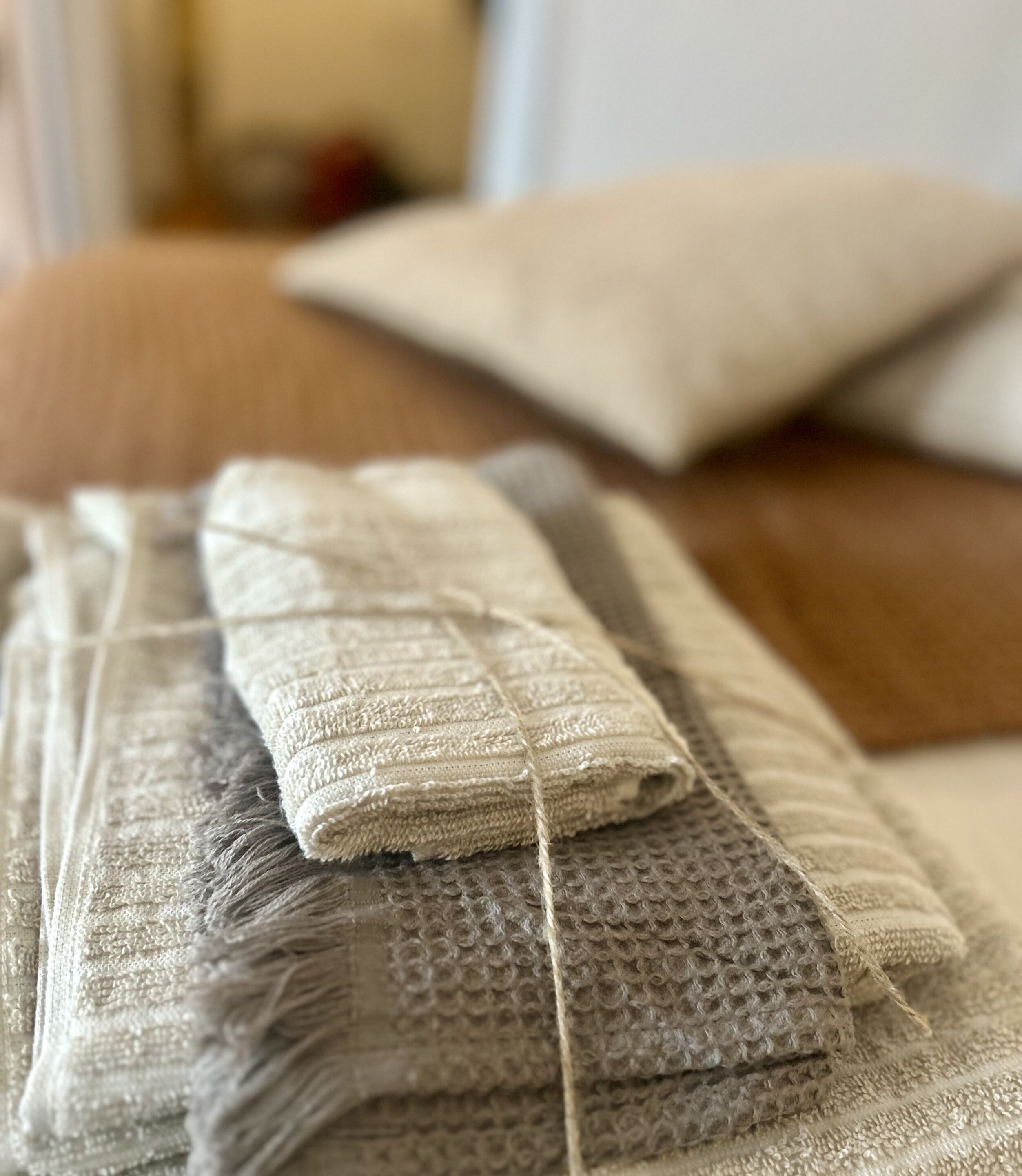 A close-up of a textured fabric with a woven pattern, possibly a blanket or towel, on a wooden surface.