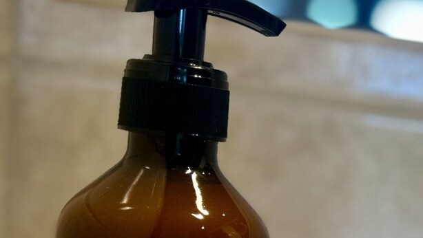 A brown bottle with a pump dispenser and a label that reads "Sapon Main."