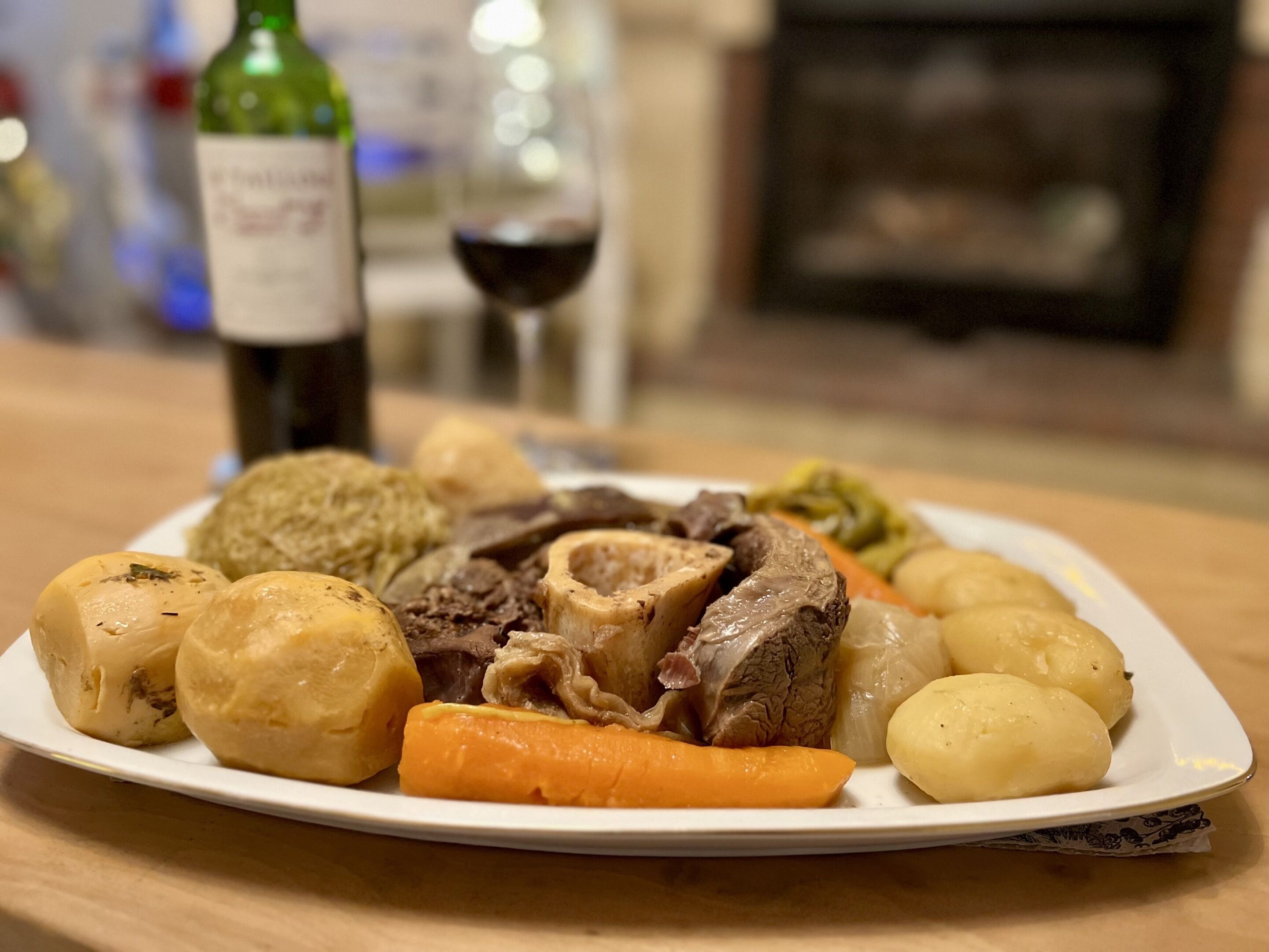 Une assiette de nourriture, avec une bouteille et un verre en arrière-plan.