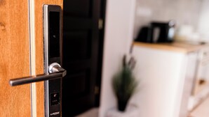 Une cuisine moderne équipée d’un four encastré, d’une machine à café et d’une plante en pot.