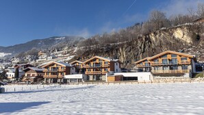 A snow-covered ski resort with wooden chalets and a mountain backdrop.
