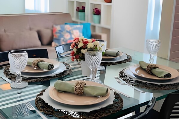 A dining table set with plates, cutlery, and decorative elements. - Jardins do Atlântico (João Pessoa)