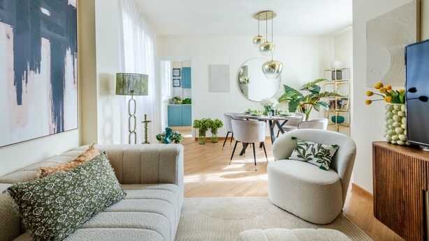 Un salon moderne comprenant un canapé, un fauteuil et un coin repas avec une table et des chaises.