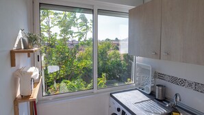 A kitchen with a large window, a washing machine, and a sink.