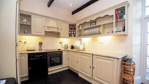 A kitchen with white cabinetry, black flooring, and a built-in oven. - Luxury and elegant lakeside lodges, Boating activities and pet friendly.
 (Sixmilebridge)