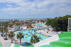 Un parc aquàtic amb diverses piscines, tobogans i una zona de platja.