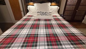 A bedroom with a plaid bedspread, a headboard with lights, and a pillow with a message. - Central 3-bedroom house in Redding with Pool & Vintage Bar Room (Redding)