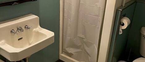 Ein Badezimmer mit Waschbecken, Toilette und Duschvorhang.