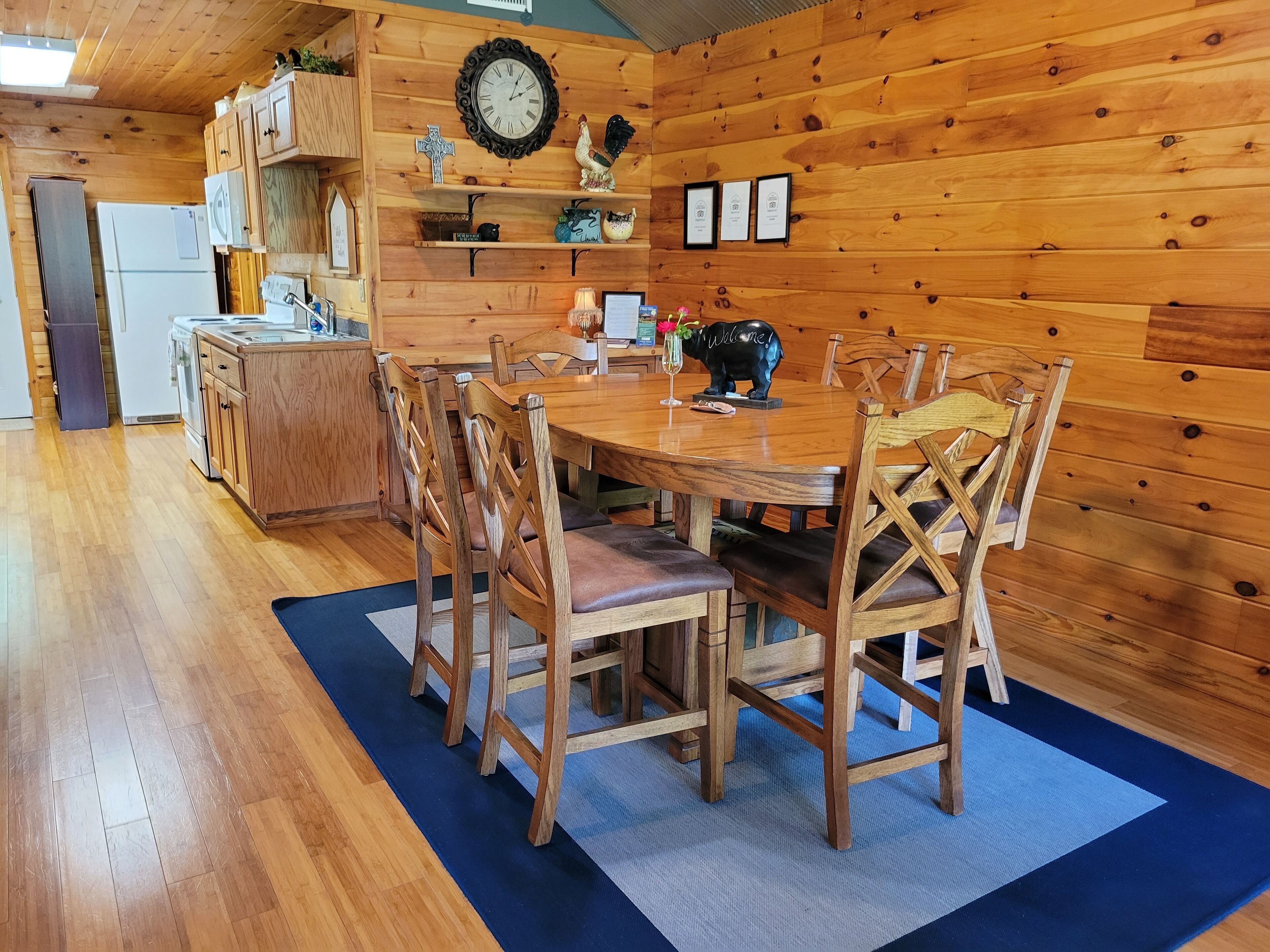 A wooden interior with a dining table, chairs, and a kitchen area.