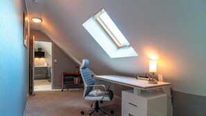 Un dormitorio moderno con tragaluces, un escritorio y una silla.