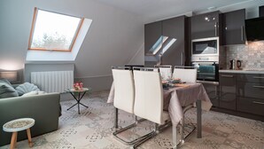 Un espacio habitable compacto con comedor, kitchenette y ventana con vistas.