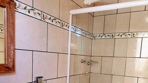 A bathroom with a toilet, sink, and shower.
