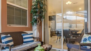 A modern living room with a sofa, a coffee table, and a decorative vase. - 4BR house at Storey Lake Resort 9min Disney (Kissimmee)