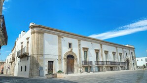 Un bâtiment historique doté d’une grande entrée centrale, de colonnes et d’une façade symétrique.
