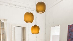 Un coin repas avec une table ronde, des chaises de couleur beige et des lampes suspendues.