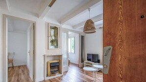A spacious living area with a fireplace, a television, and a dining area with a table and chairs.