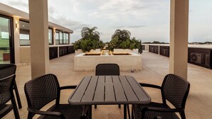 Eine Außenpatio mit Tisch und Stühlen, einem Wasserspiel und Kübelpflanzen.