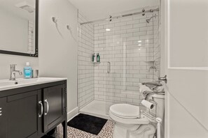 A modern bathroom with a shower, toilet, and sink. - Washington Square West (Philadelphia)